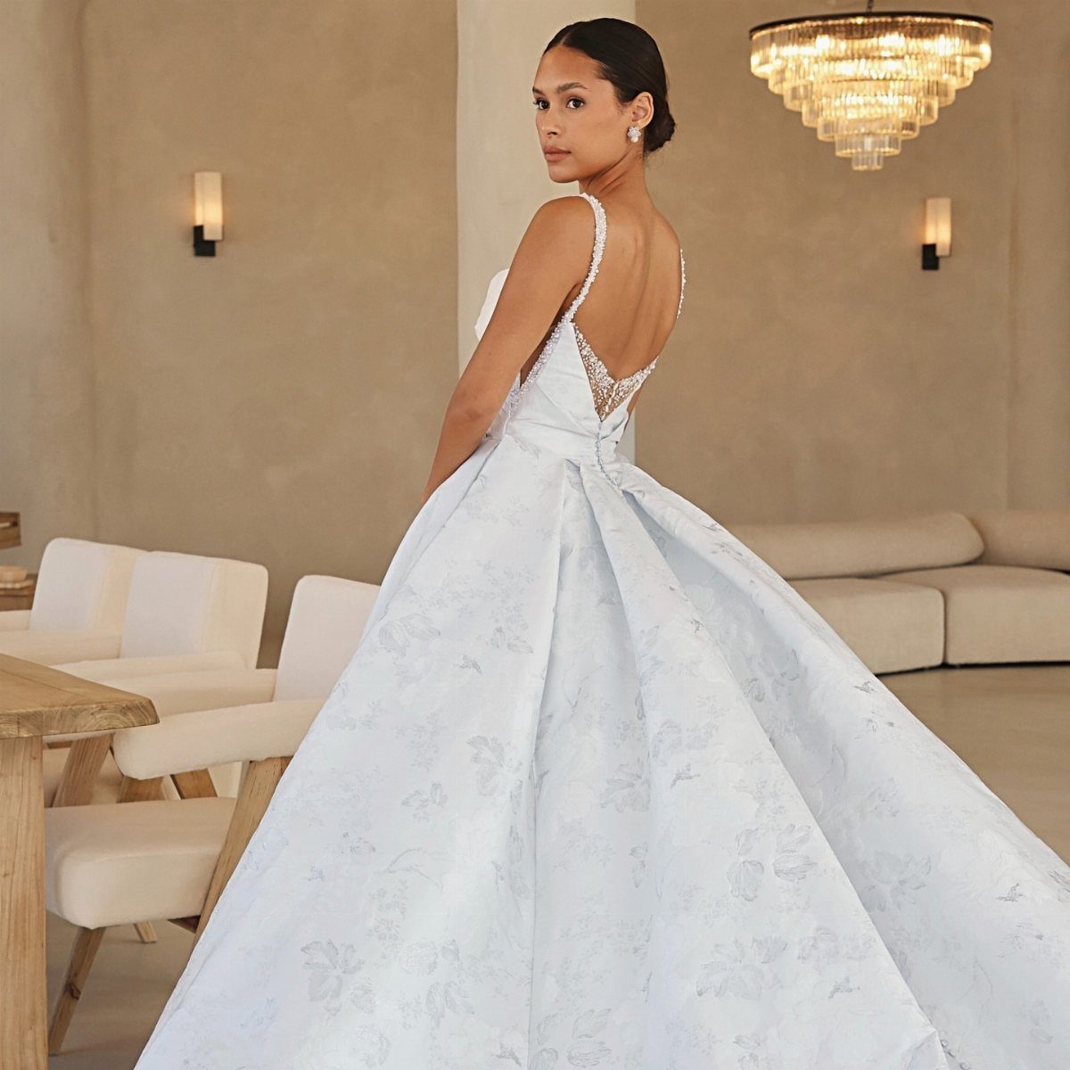 Woman in a voluminous light blue floral ballgown wedding dress in a modern room