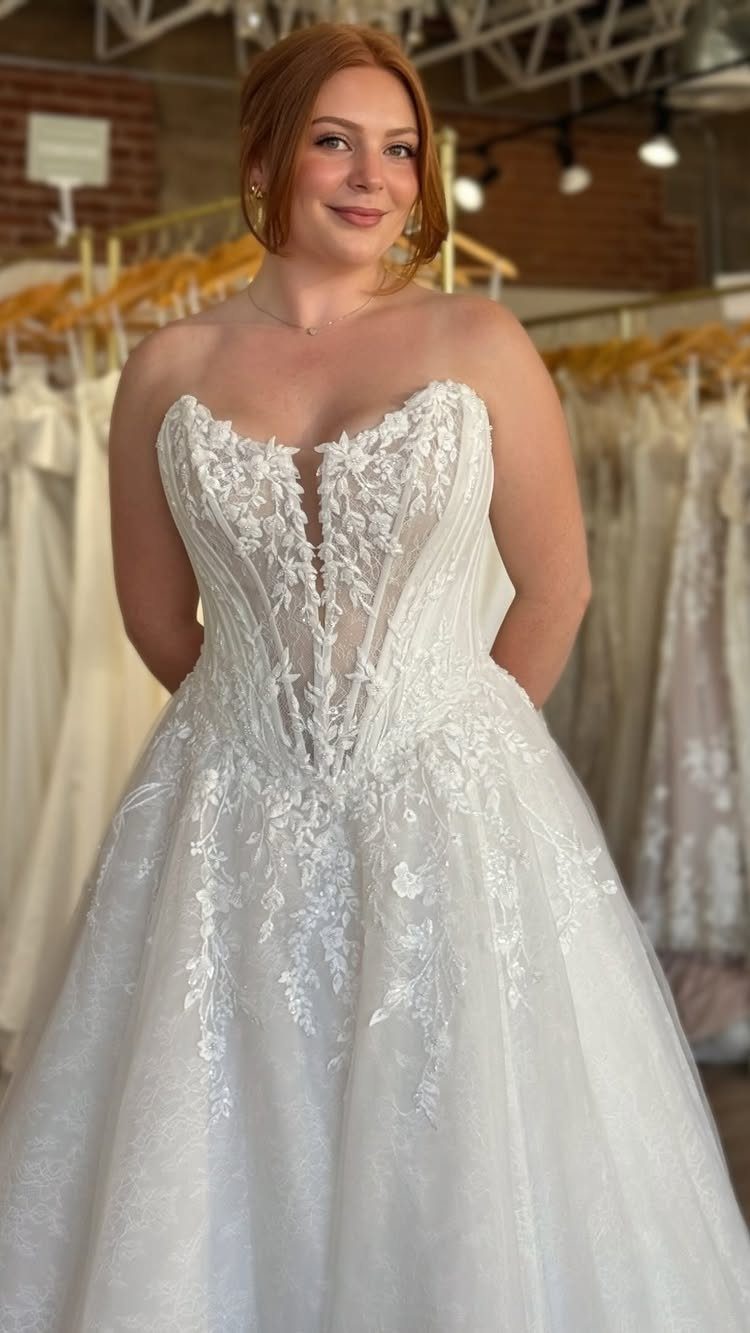 Woman wearing a white strapless wedding gown with a visible sheer corset bodice.