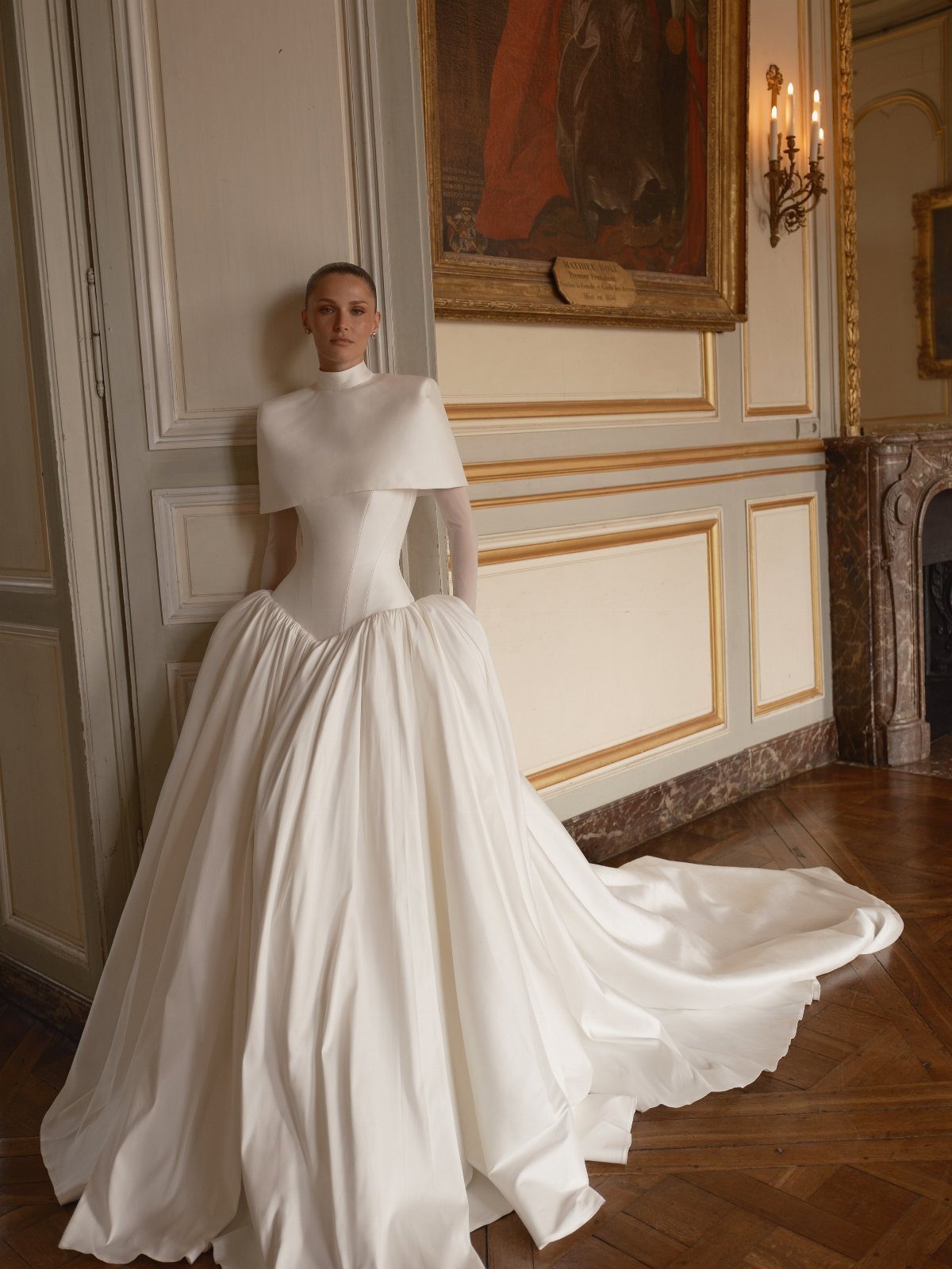 Woman in a white sculptural minimalist wedding gown with a voluminous full skirt.