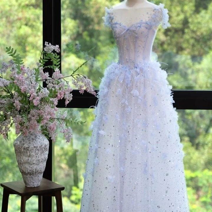 Light blue beaded wedding gown with 3D floral details on a mannequin