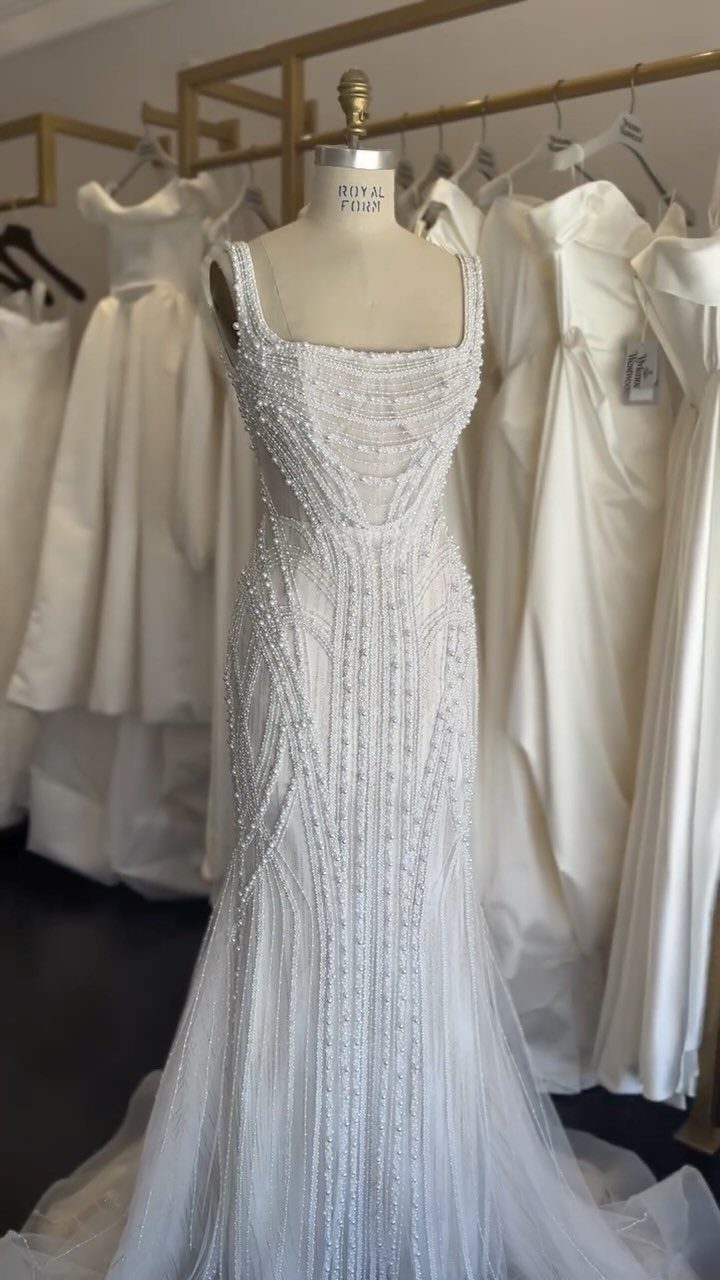 Beaded wedding dress on a mannequin with detailed beadwork along the square neckline.