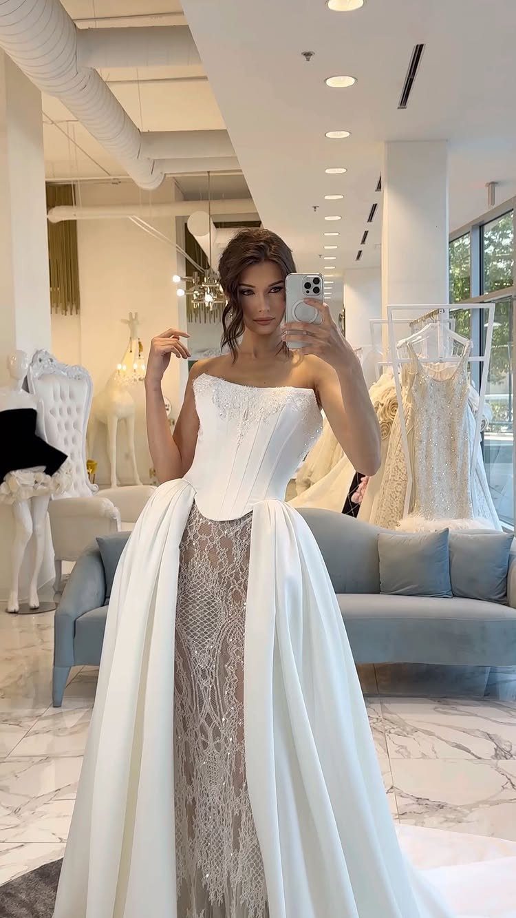 Woman in a white strapless wedding dress with a beaded shimmering silver underskirt.