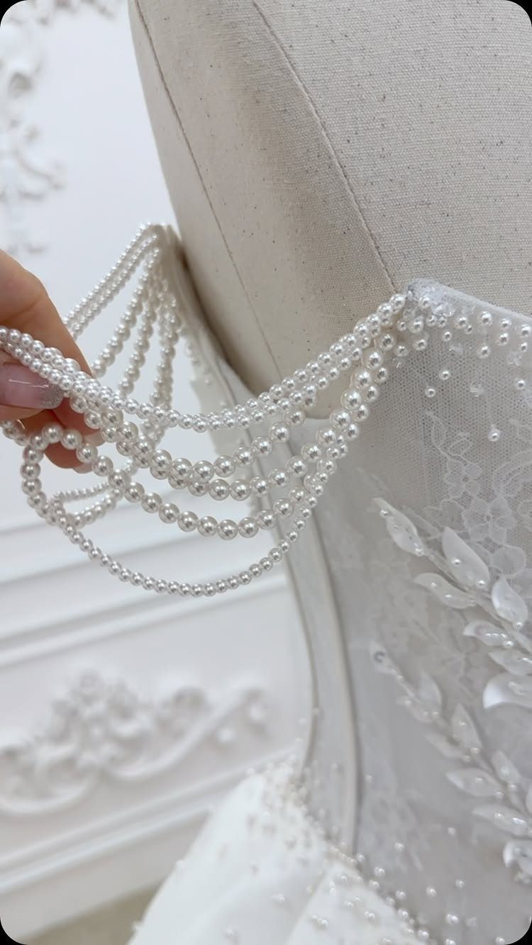 White wedding dress with floral lace and draped beaded pearl details.
