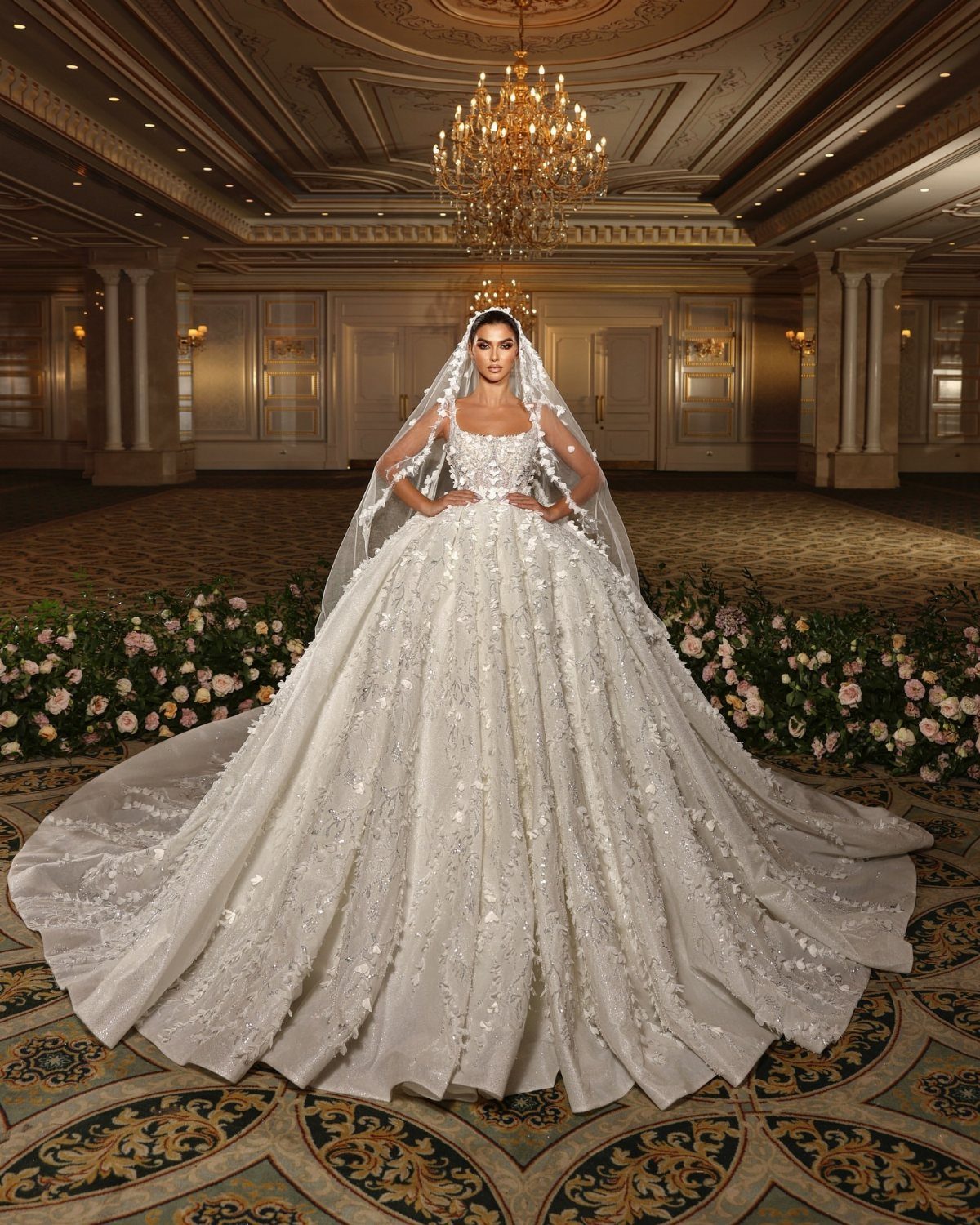 Woman in a voluminous white lace and tulle wedding gown in a ballroom