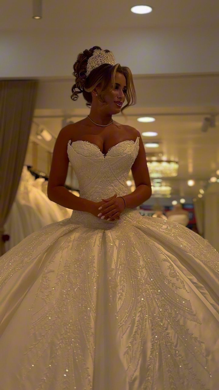 Woman in a voluminous white princess wedding dress and tiara in a bridal shop
