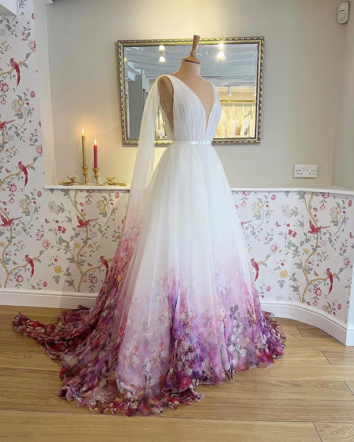 White wedding gown on mannequin with purple and pink ombre floral skirt hem