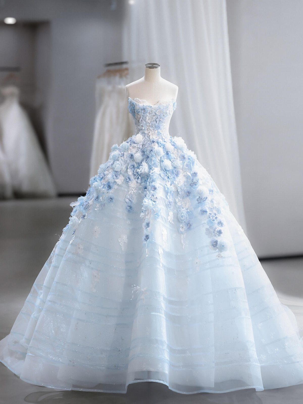 Light blue organza ball gown with 3D floral appliqués on a mannequin
