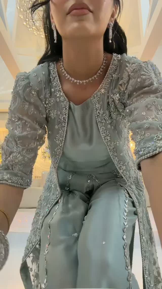 Person wearing a shimmering sage green embellished outfit with matching jewelry.