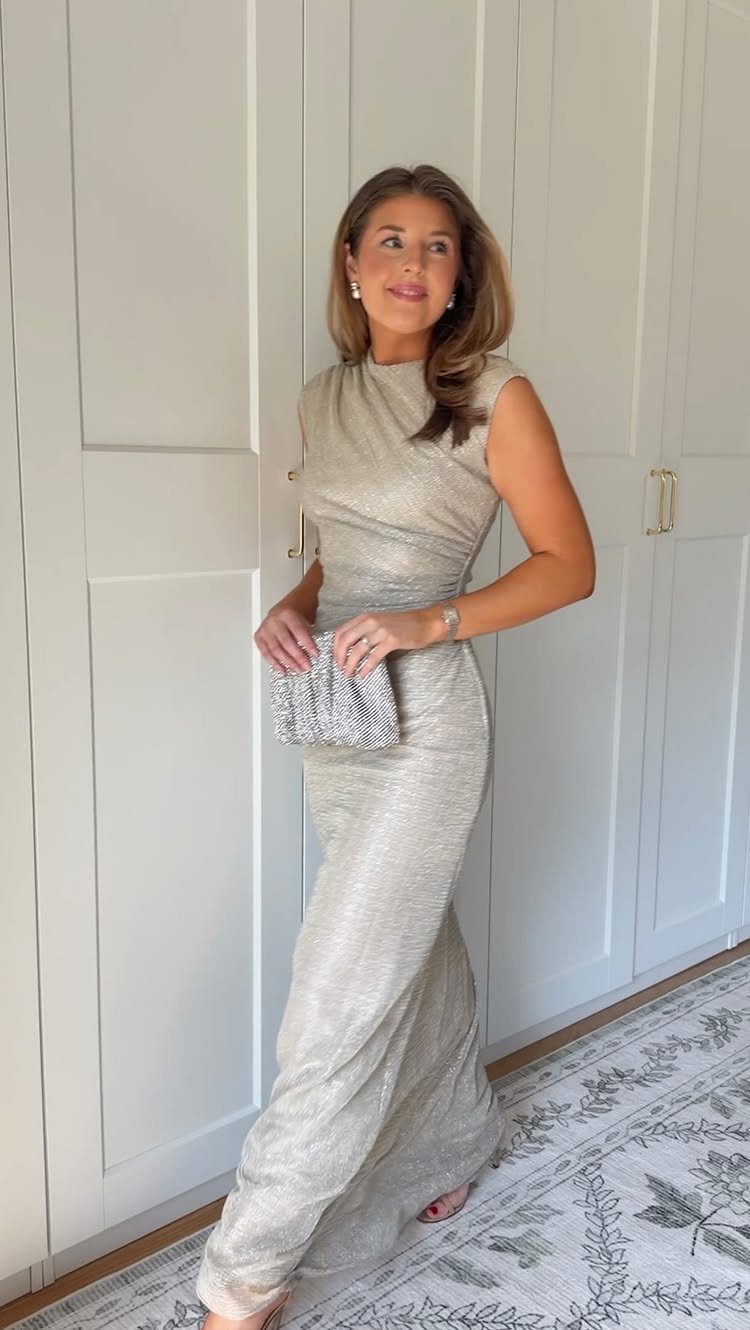 Woman in a shimmering champagne floor-length gown holding a silver glittery clutch bag.