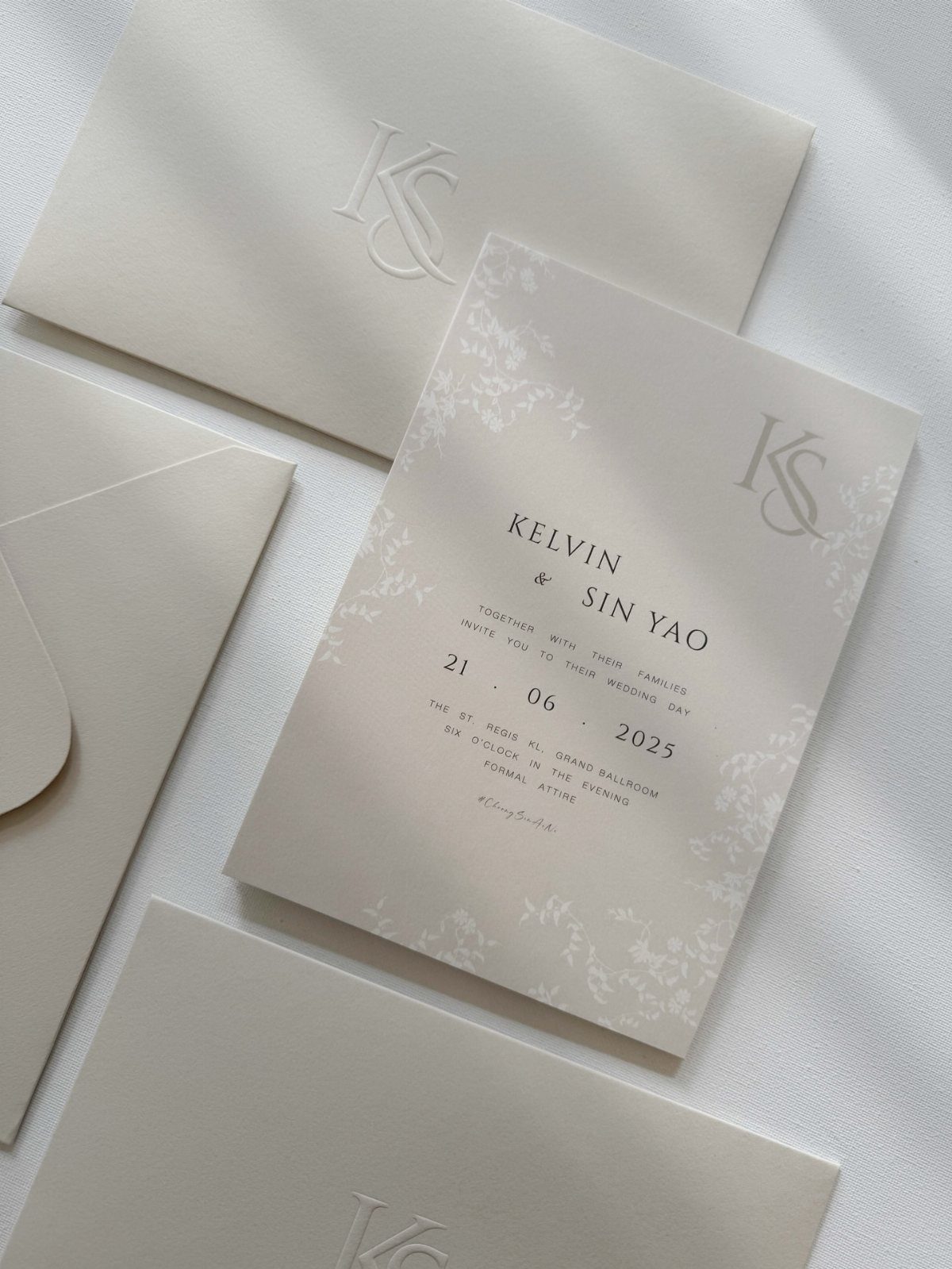 Cream colored wedding invitation suite with matching envelopes and elegant black typography.