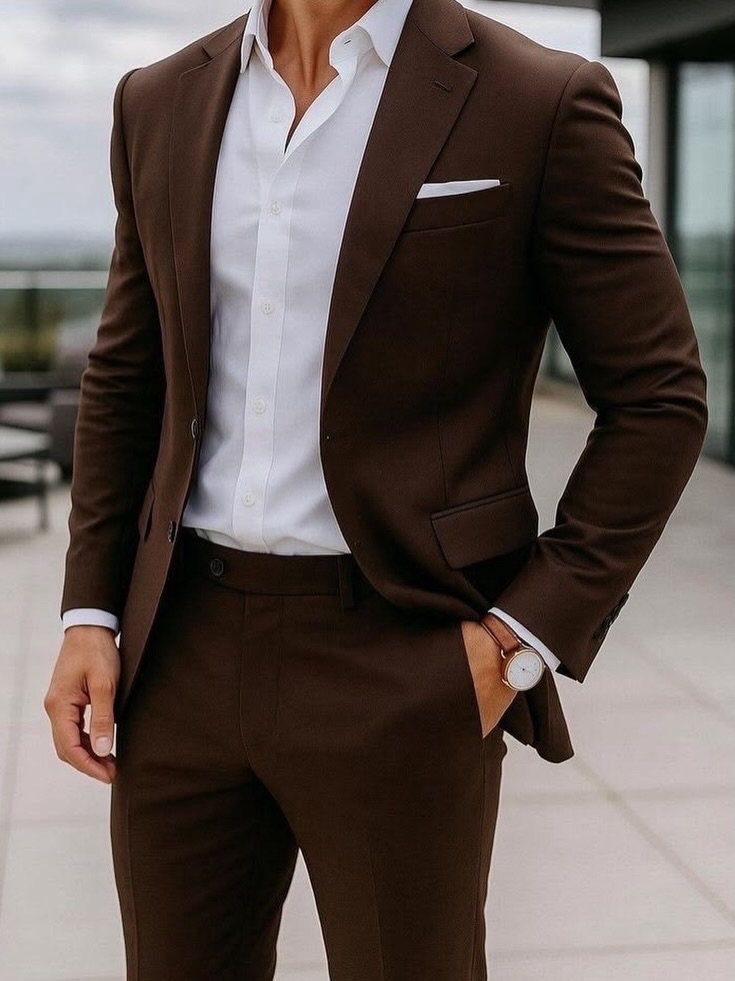 Man wearing a tailored dark brown suit and white shirt on a balcony
